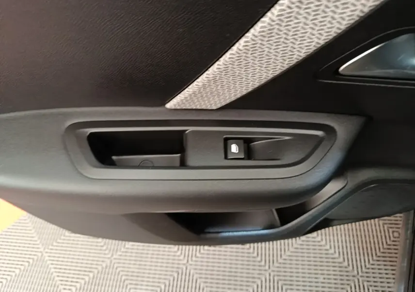 Poignée intérieure noire côté gauche avec bouton de verrouillage sur porte d’une Citroën C4 X PureTech 130 2023.