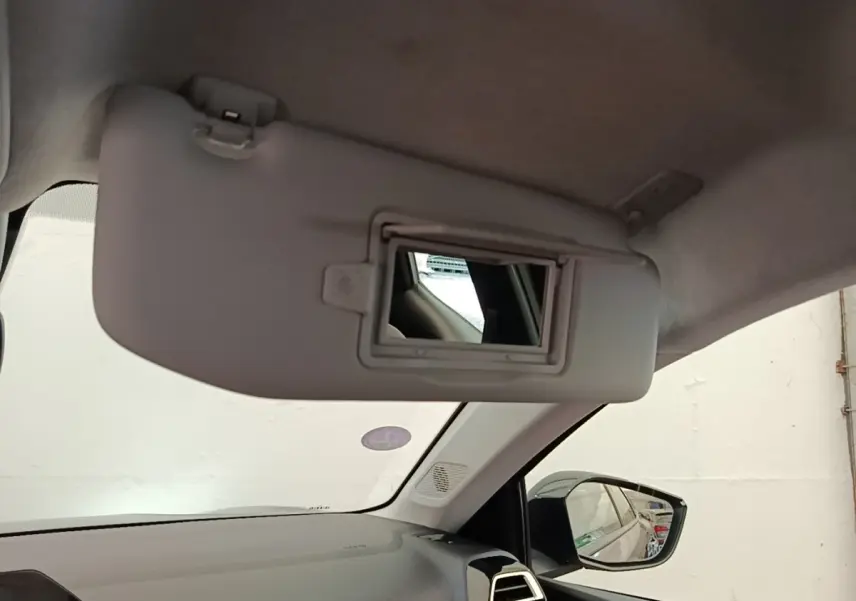 Intérieur de la Citroën C4 X noir, vue du pare-soleil avec miroir et rétroviseur côté droit visible.