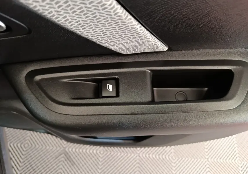 Détail de la commande de lève-vitre sur la porte intérieure d'une Citroën C4 X noire.