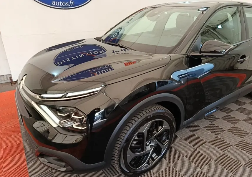 Vue 3/4 avant droit de la Citroën C4 X noire 2023 avec phares LED et jantes alliage distinctives.