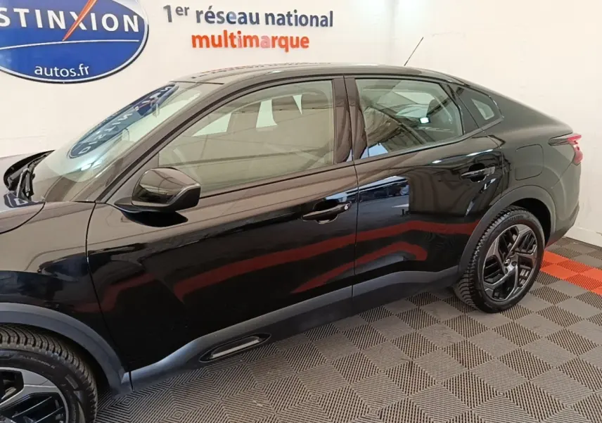 Vue côté gauche de la Citroën C4 X noire 2023, finition Feel Pack, avec jantes alliage et lignes fluides.