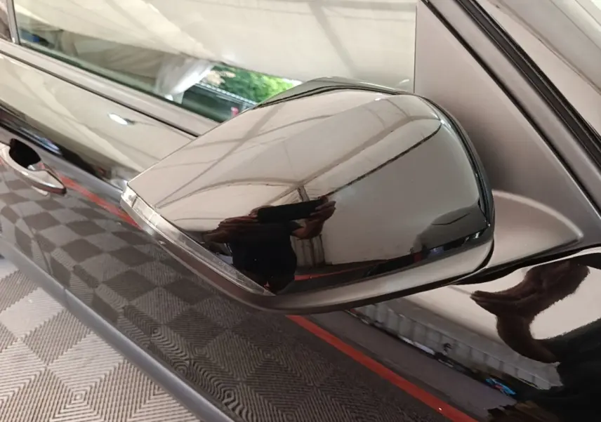 Rétroviseur côté gauche noir brillant de la Citroën C4 X PureTech 130, avec poignée de porte visible en arrière-plan.