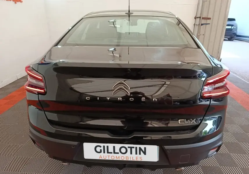 Vue arrière d'une Citroën C4 X noire 2023 avec feux LED distinctifs et logo centré sur le coffre.