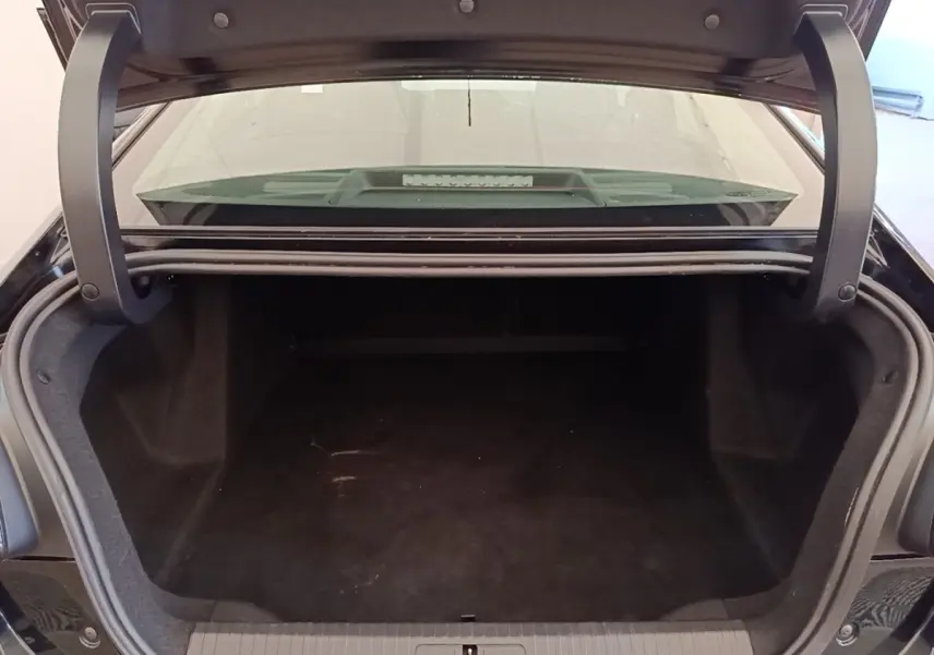 Coffre ouvert vu de l'arrière d'une Citroën C4 X noire, montrant un espace de chargement vide et spacieux.