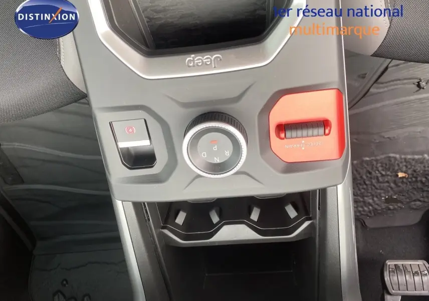 Vue rapprochée de la console centrale du Jeep Compass noir Vulcano, montrant la molette de sélection de vitesse et le bouton de frein à main.