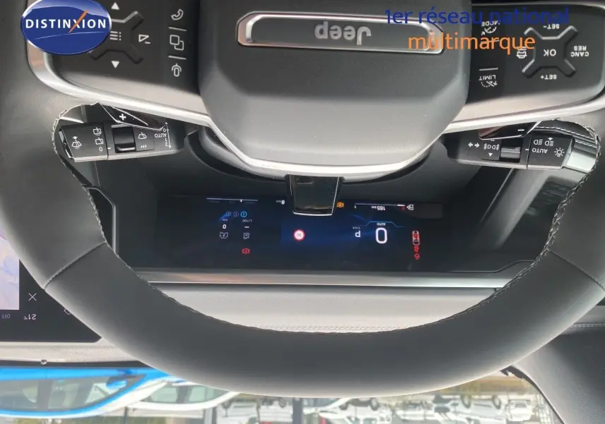 Vue rapprochée du volant noir avec logo Jeep et tableau de bord numérique du Jeep Compass 2026 noir Vulcano.