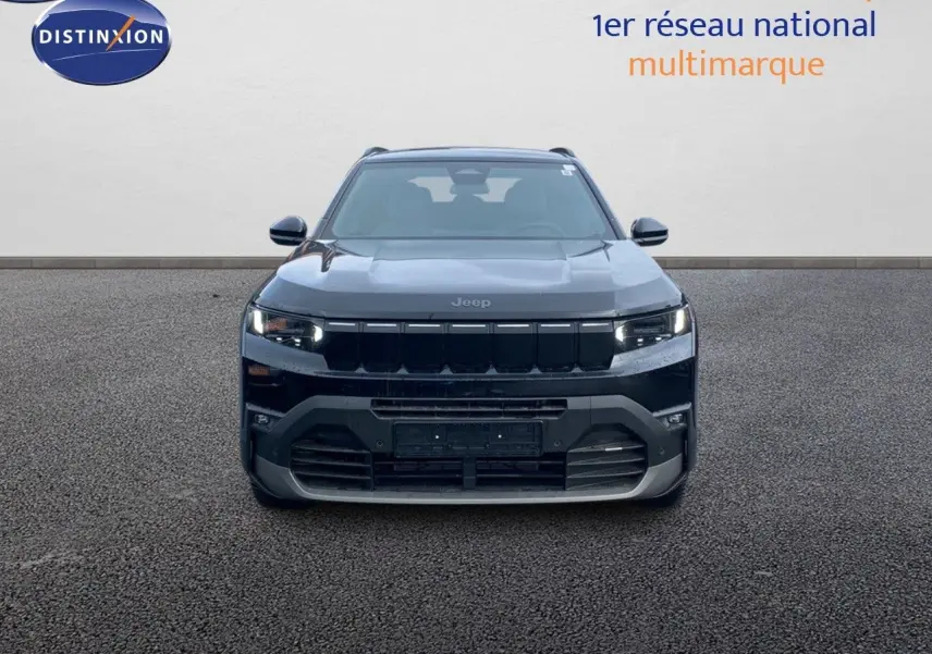 Vue frontale d'un Jeep Compass noir Vulcano métal avec calandre noire et phares LED allumés.