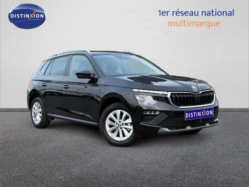 Vue 3/4 avant droite d'un Skoda Kamiq 2024 noir Magic nacré avec calandre distinctive et jantes argentées.