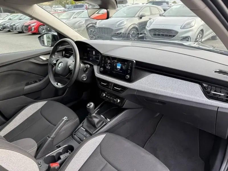Vue intérieure côté conducteur du Skoda Kamiq 2024, avec tableau de bord moderne et sellerie bicolore grise.
