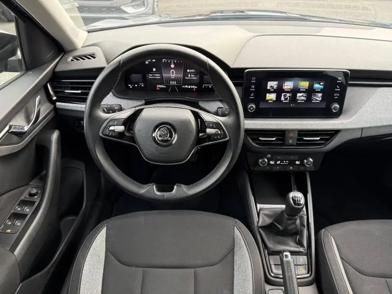 Vue intérieure frontale du Skoda Kamiq 2024 noir Magic nacré, avec tableau de bord numérique et boîte manuelle.