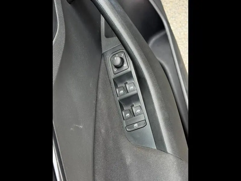 Gros plan sur la commande des vitres électriques et réglage des rétroviseurs côté conducteur d’un Skoda Kamiq noir Magic nacré 2024.