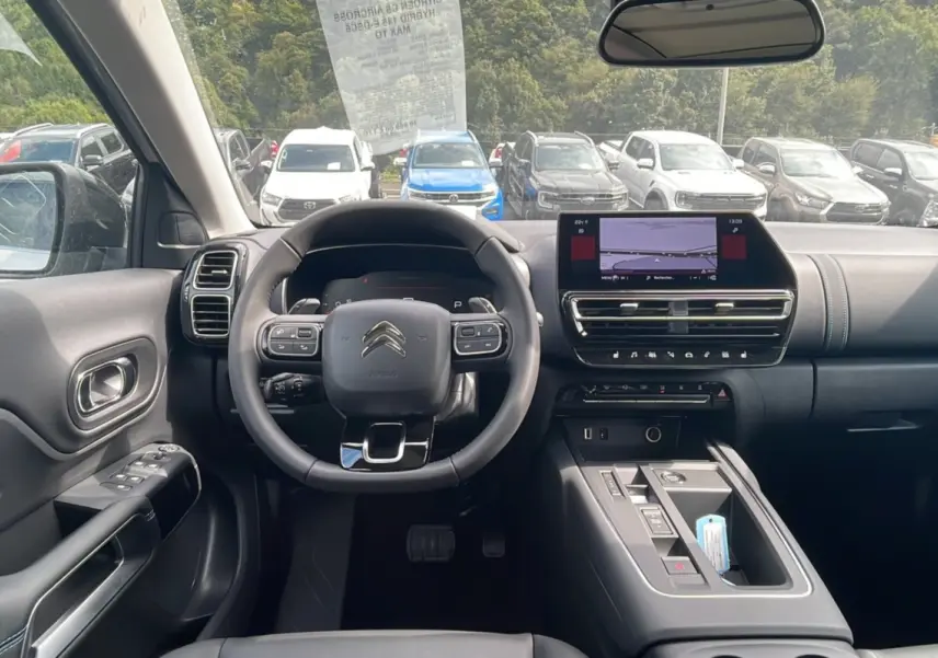 Intérieur du Citroën C5 Aircross Hybrid 2025, vue frontale du poste de conduite avec volant multifonction et écran tactile.