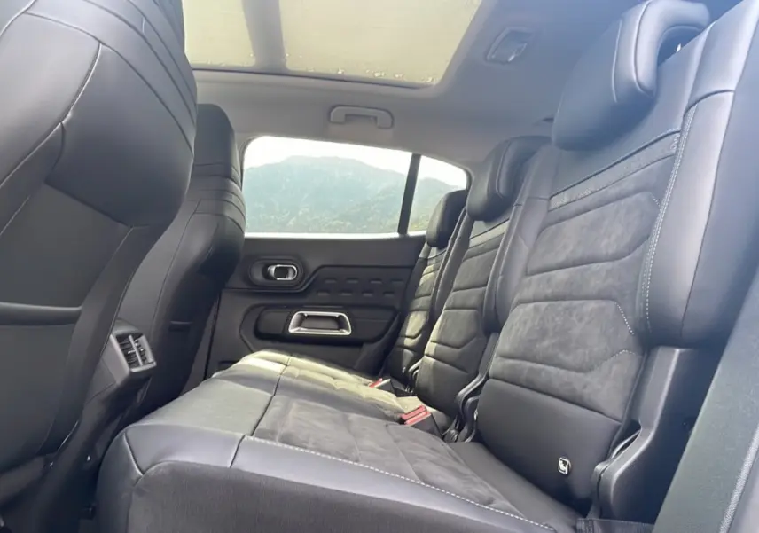 Vue intérieure côté droit des sièges arrière en cuir noir du Citroën C5 Aircross Hybrid 2025 avec toit panoramique.