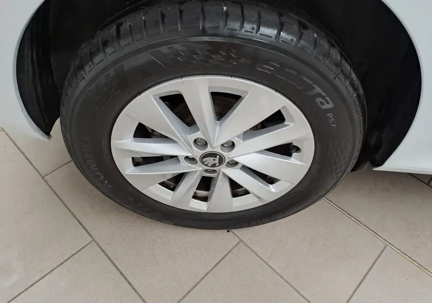 Gros plan sur la roue avant gauche du Skoda Kamiq blanc Lune, mettant en valeur la jante en alliage et le pneu Kumho Ecsta.