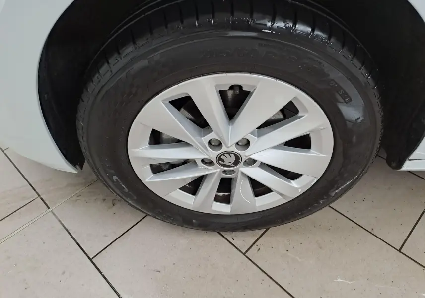 Gros plan sur la roue avant droite blanche Lune d’un Skoda Kamiq 2025 avec jante alliage au design à rayons.