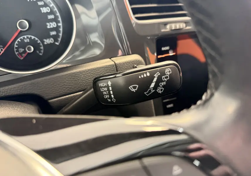 Gros plan sur la commande d’essuie-glace dans l’habitacle gris d’une Volkswagen Golf TSI 130 Confortline 2019.