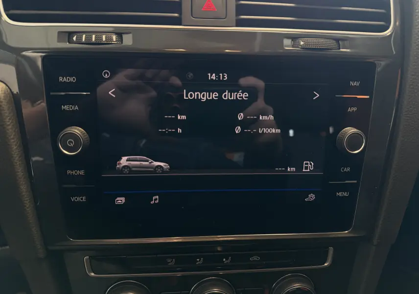 Vue rapprochée de l'écran tactile central noir affichant les données de conduite d'une Volkswagen Golf gris 2019.