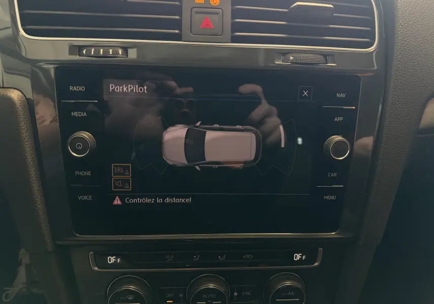 Vue rapprochée de l’écran tactile central de la Volkswagen Golf gris 2019 affichant le système ParkPilot avec alertes de distance.