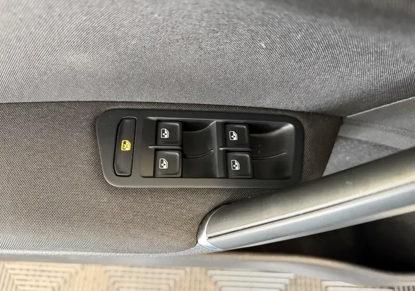 Gros plan sur les commandes des vitres électriques côté conducteur d’une Volkswagen Golf TSI 130 Confortline gris 2019.
