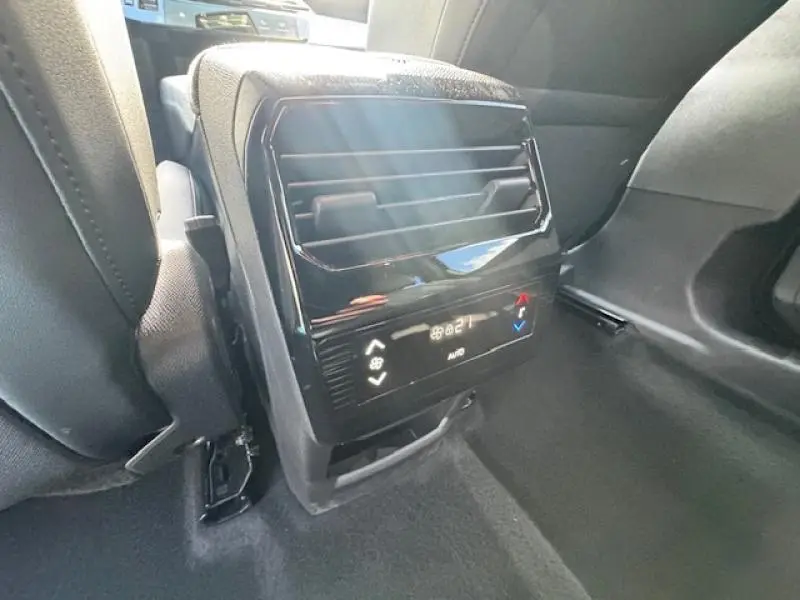 Vue rapprochée de la console de climatisation arrière noire du Peugeot 5008 Hybrid 2025 entre les sièges arrière.