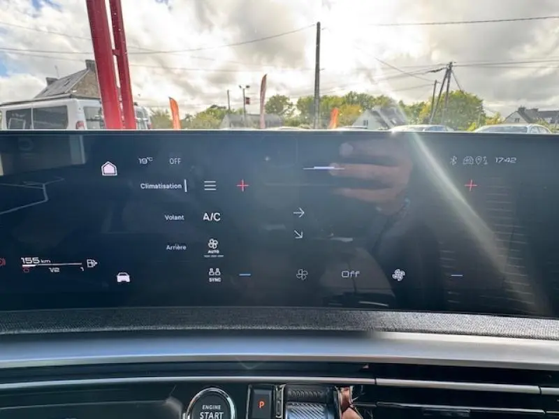 Écran tactile du tableau de bord du Peugeot 5008 Hybrid noir, affichant les commandes de climatisation et d’assistance.