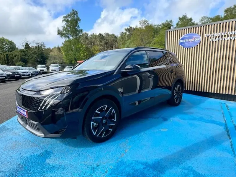 Peugeot 5008 Hybrid noir Perla Nera vue 3/4 avant droit, avec jantes alu et calandre distinctive noire.
