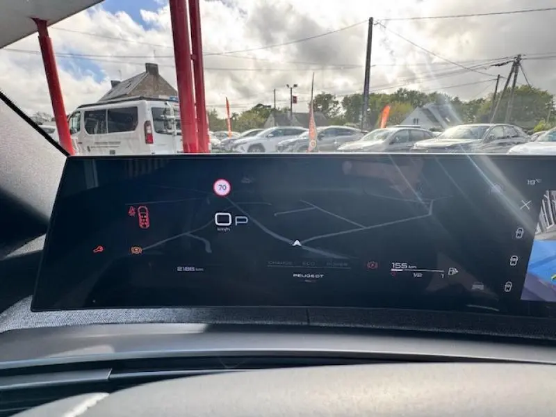 Vue intérieure du tableau de bord numérique du Peugeot 5008 Hybrid noir, affichant la navigation et les alertes de conduite.