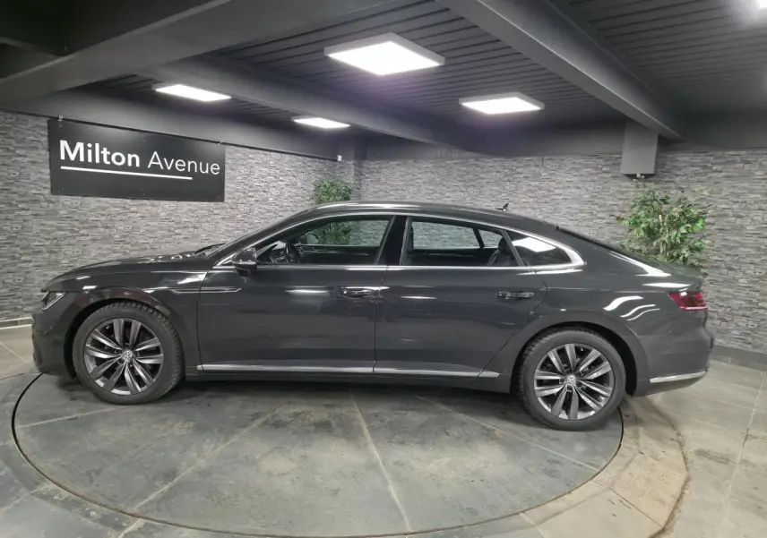 Volkswagen Arteon gris en profil droit, avec jantes alliage 18" et badge R-Line visible sur les portes.