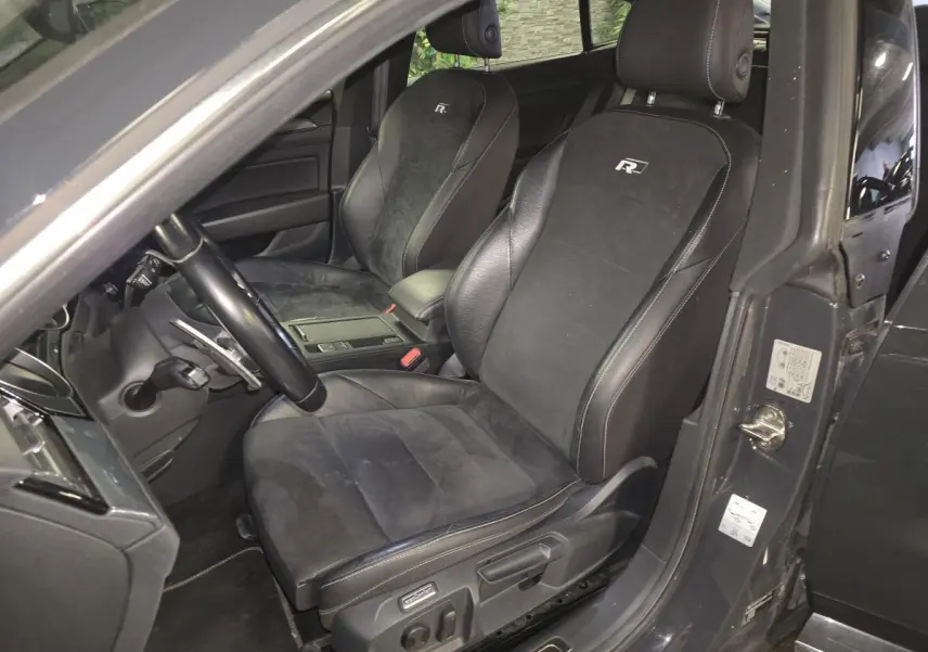 Vue intérieure côté conducteur du Volkswagen Arteon gris, sièges sport en cuir noir avec logo R brodé.