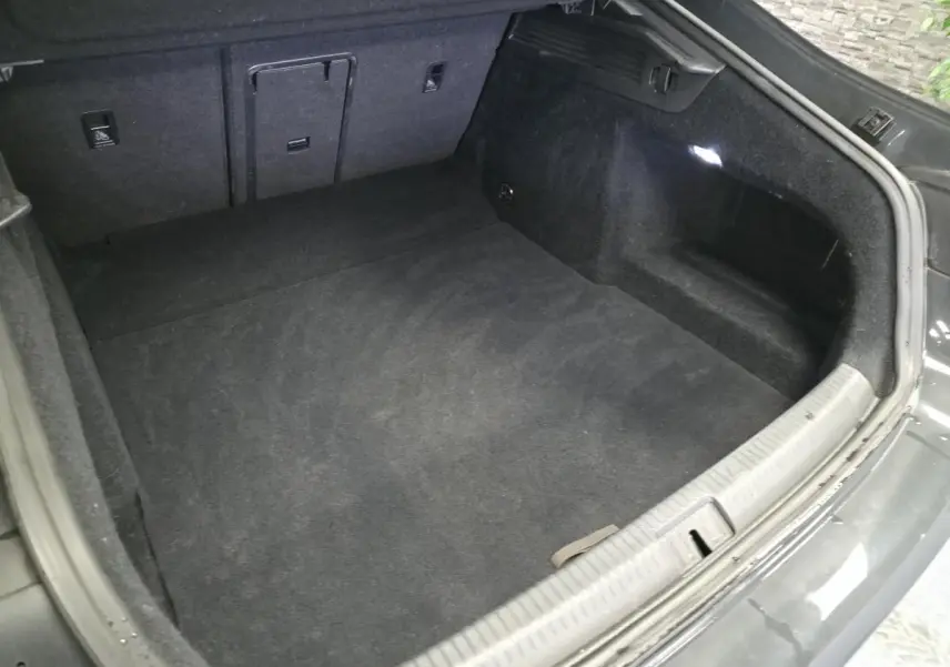 Coffre ouvert vu de dessus d’un Volkswagen Arteon gris 2020, intérieur noir avec éclairage latéral LED.