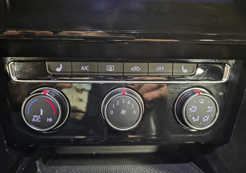 Gros plan sur la console centrale noire brillante du Volkswagen Arteon 2020 avec commandes de climatisation manuelles.