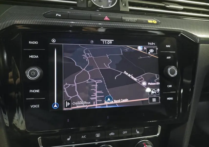 Écran tactile central du Volkswagen Arteon 2020 gris, affichant la navigation GPS avec horloge analogique au-dessus.