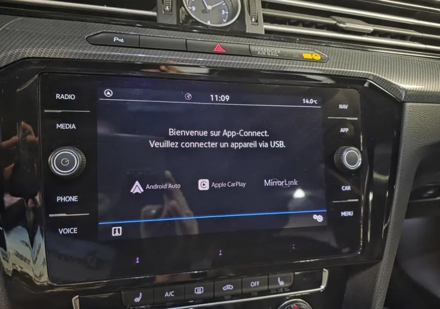 Vue rapprochée de la console centrale noire brillante du Volkswagen Arteon 2020 avec écran tactile App-Connect allumé.