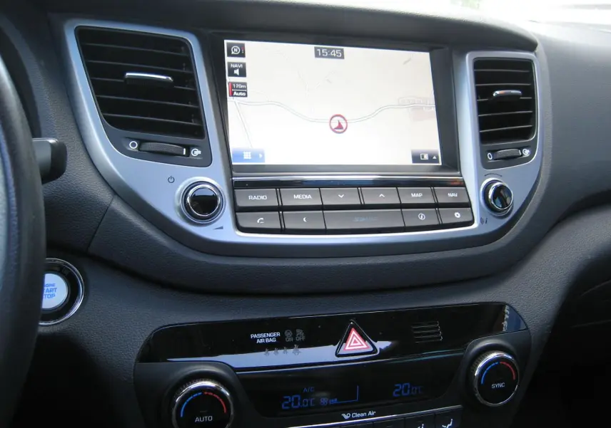 Vue rapprochée du tableau de bord du Hyundai Tucson 2016, avec écran tactile de navigation et commandes de climatisation.