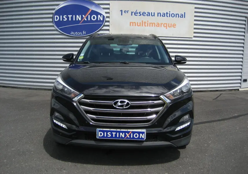 Vue avant d'un Hyundai Tucson noir fantom metal 2016 avec calandre chromée et feux LED allumés.