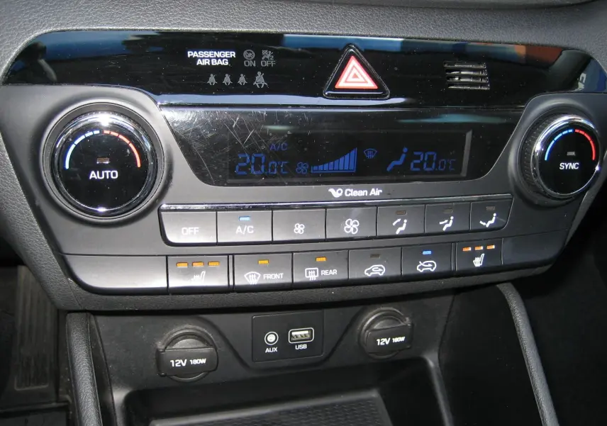 Détail du tableau de bord du Hyundai Tucson noir fantom métal 2016, montrant la climatisation digitale et commandes chauffantes.