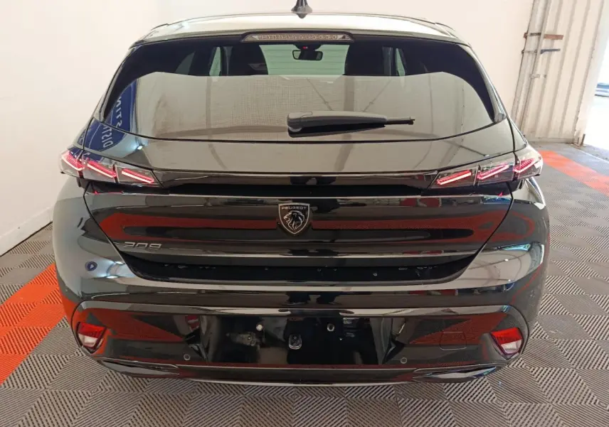 Vue arrière d'une Peugeot 308 noire 2026 avec feux LED distinctifs et logo lion central sur hayon.