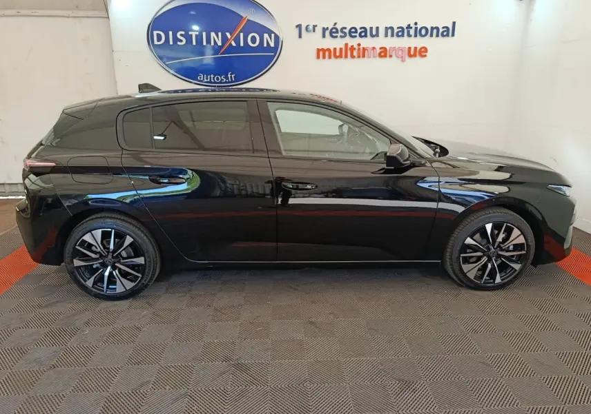 Profil droit d'une Peugeot 308 noire 2026, avec jantes alliage et vitres teintées, en intérieur showroom.