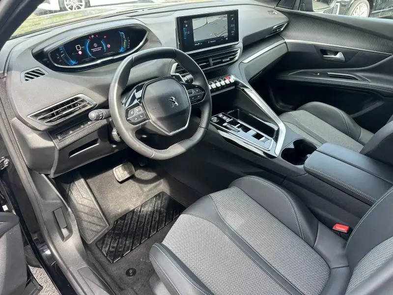 Vue intérieure côté conducteur du Peugeot 3008 Hybride Rechargeable 2024 noir Perla Nera, avec tableau de bord digital et écran tactile central.