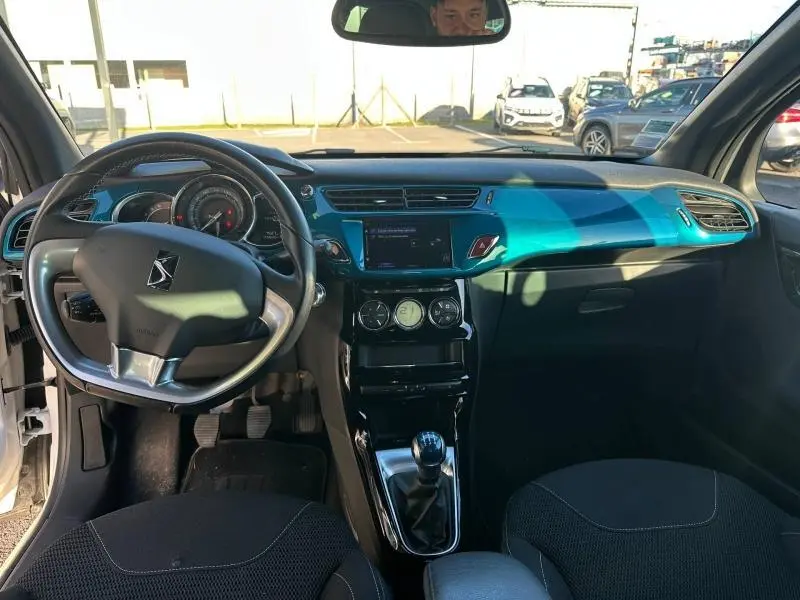 Vue intérieure avant de la DS3 2016 noire, tableau de bord bleu brillant avec volant cuir et boîte manuelle.