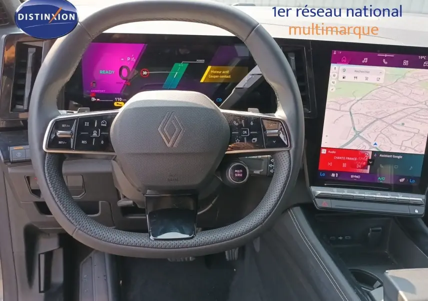 Vue frontale du volant Renault sur tableau de bord numérique avec écran tactile vertical et finition noire intérieure.