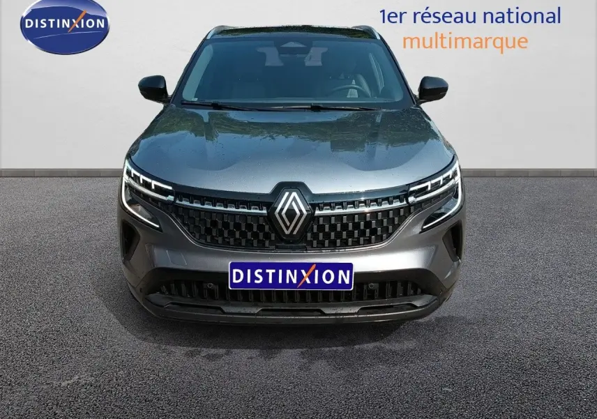 Vue frontale du Renault Austral E-Tech gris schiste métal avec calandre noire et logo Renault central lumineux.