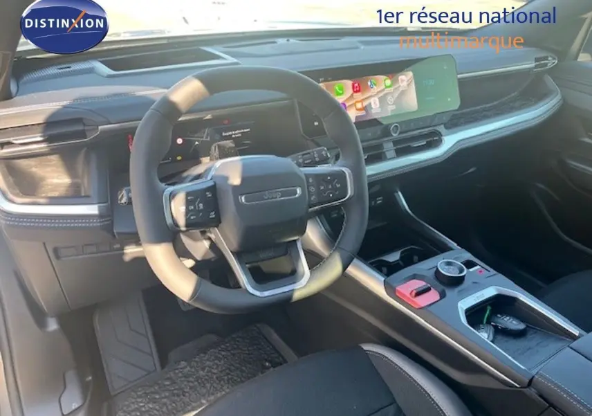 Vue intérieure du tableau de bord et volant du Jeep Compass 2026, finition Summit, avec écran tactile et console moderne.