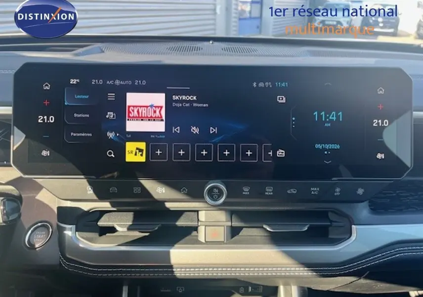 Vue du tableau de bord du Jeep Compass 2026, écran tactile large affichant radio et climatisation, ambiance intérieure noire moderne.