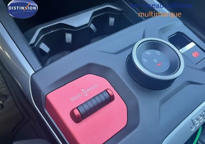 Gros plan sur la console centrale du Jeep Compass 2026, avec molette de boîte auto et sélecteur terrain rouge.