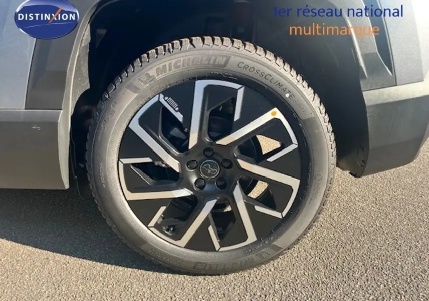 Gros plan sur la roue avant droite du Jeep Compass gris Yosemite métal avec jante noire et argentée au design moderne.