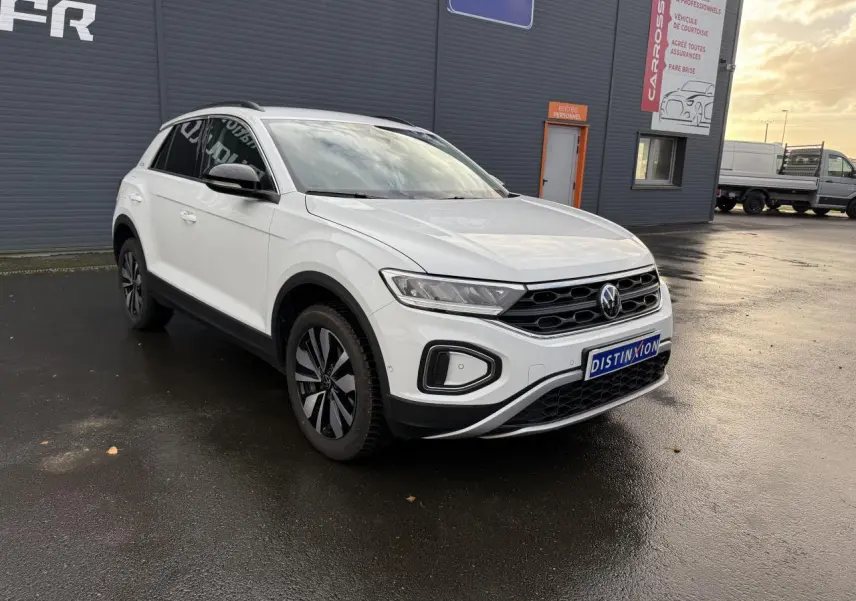 Volkswagen T-Roc blanc pur en 3/4 avant droit, avec jantes alliage Zürich et calandre noire distinctive.
