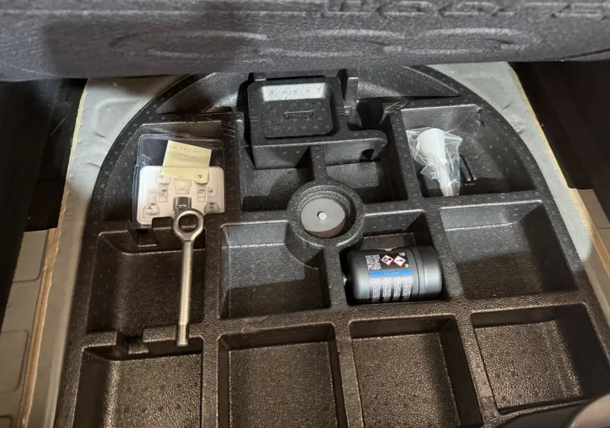 Rangement sous le coffre d'une FIAT 500X noire 2021, montrant l'emplacement des outils et accessoires.