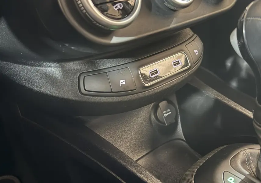 Gros plan sur la console centrale noire du Fiat 500X 2021 avec ports USB et prise 12V visibles.