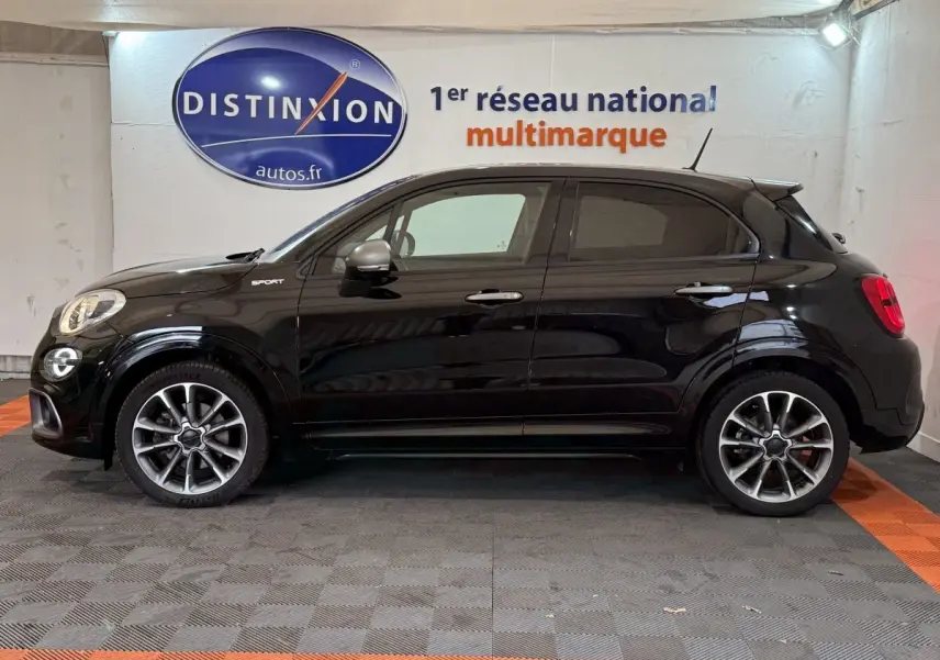 Profil côté gauche d'une FIAT 500X Sport noire avec jantes alliage et rétroviseurs argentés dans un showroom.
